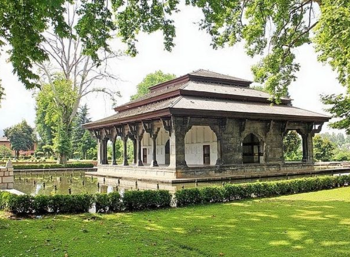 Scenic Kashmir landscape with snow-capped mountains, green valleys, and a lake on a 7-day Kashmir itinerary.