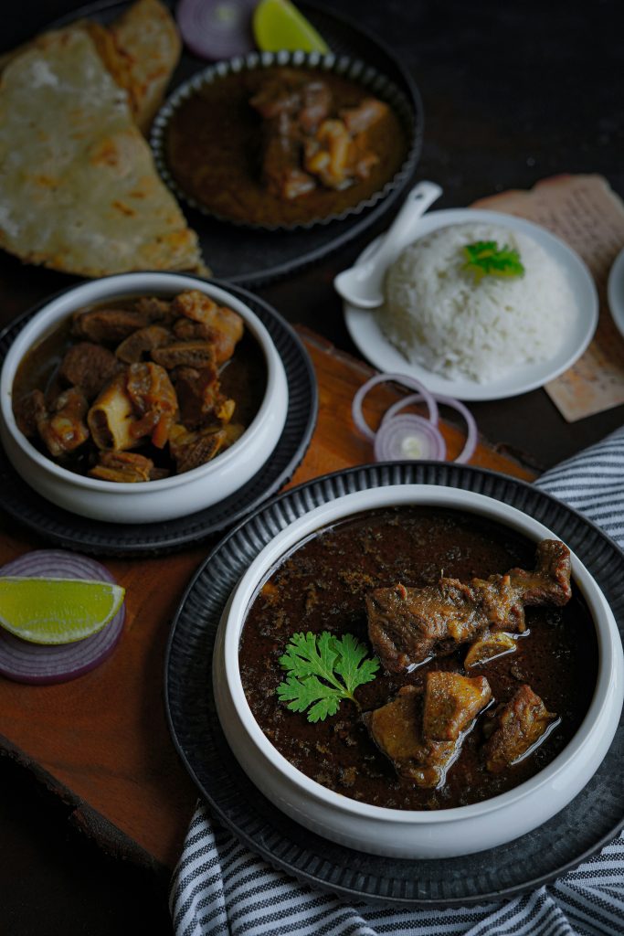 one bowl of mutton gravy and pieces. one bowl of dry mutton pieces, served with rice