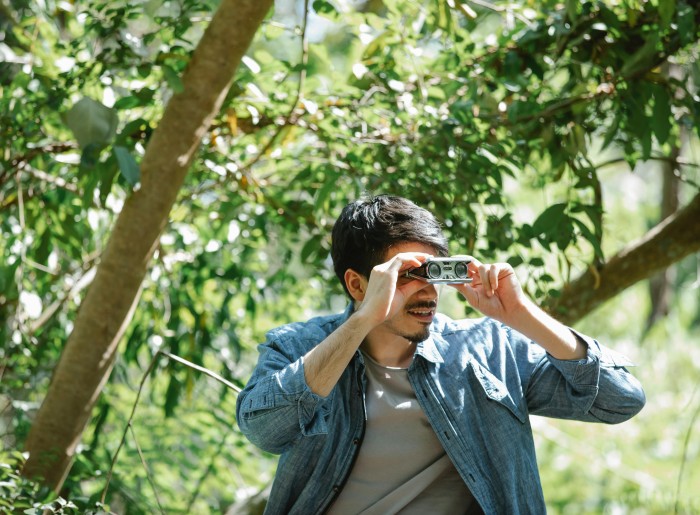 A man carrying binoculars when visiting the wildlife sanctuaries of India