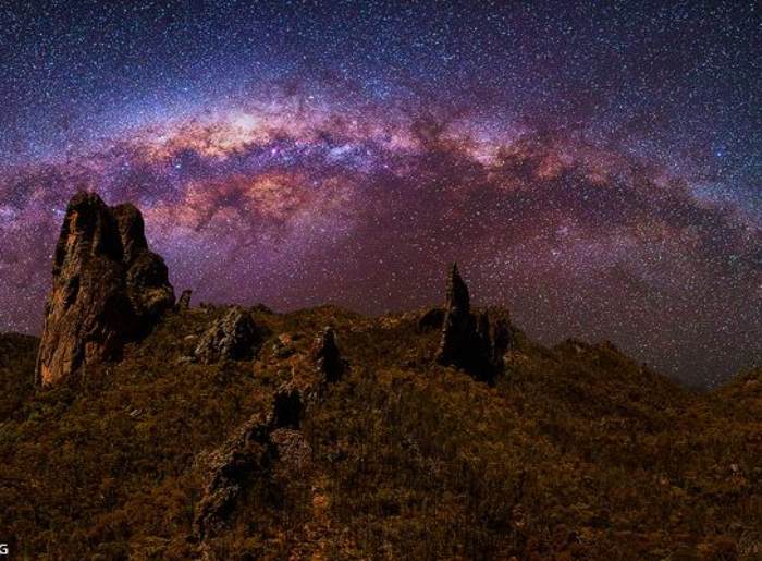  Milky Way visible over a dark desert landscape