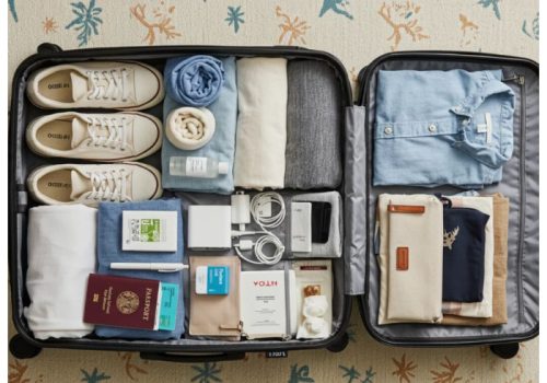 Organised suitcase with travel essentials and packing items
